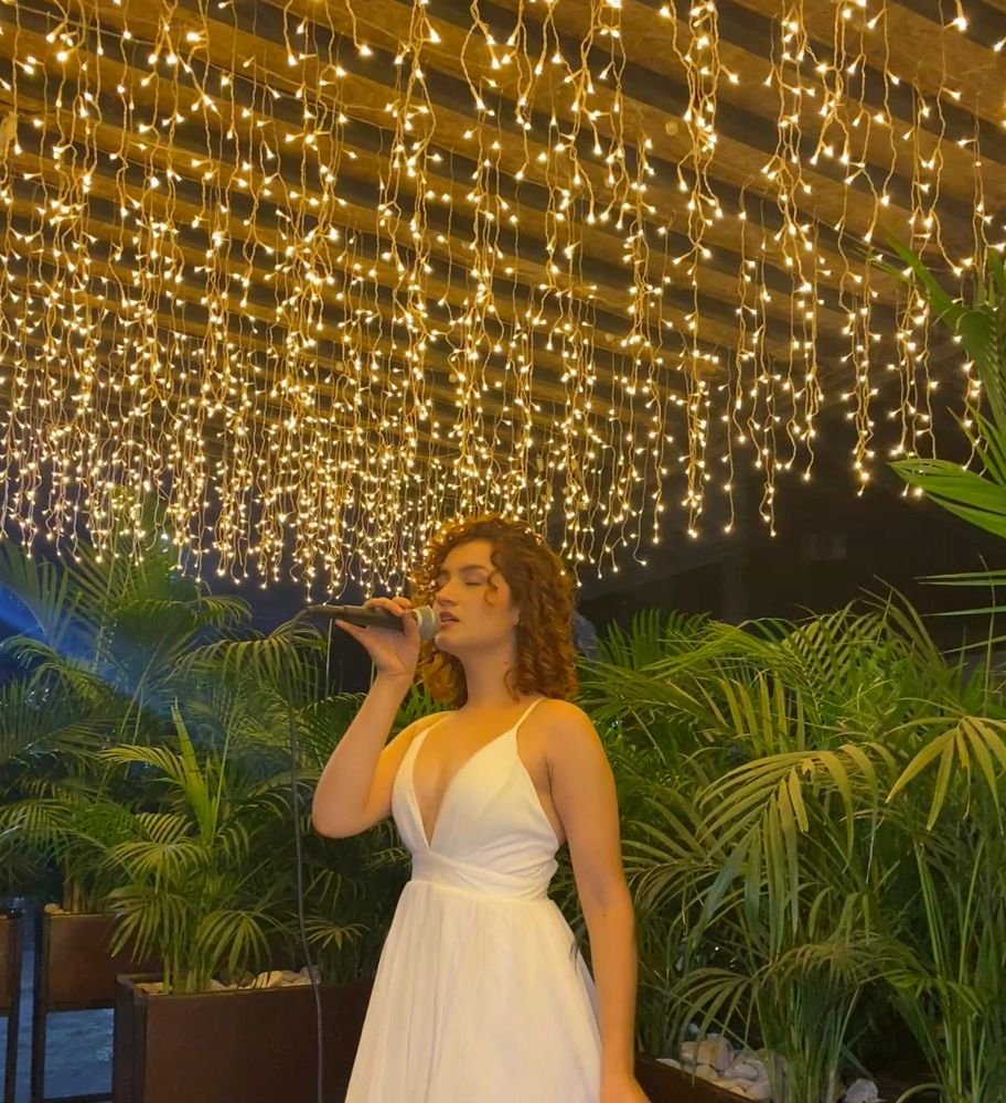 Kristal cantando bajo luces cálidas